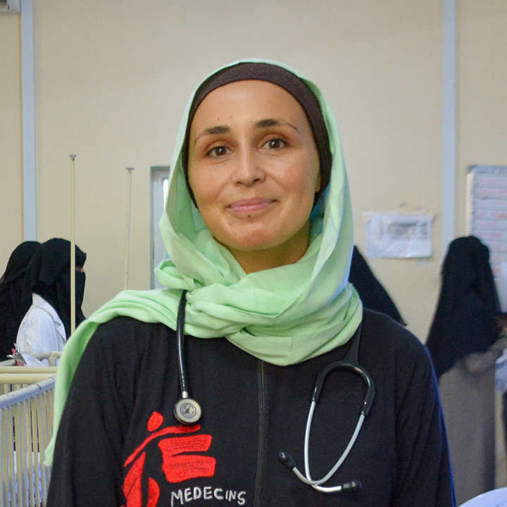 Barnläkaren Mónica Costeira, som arbetar på vårt sjukhus i al-Qanawis, Jemen, håller en liten bebis i famnen och ler.