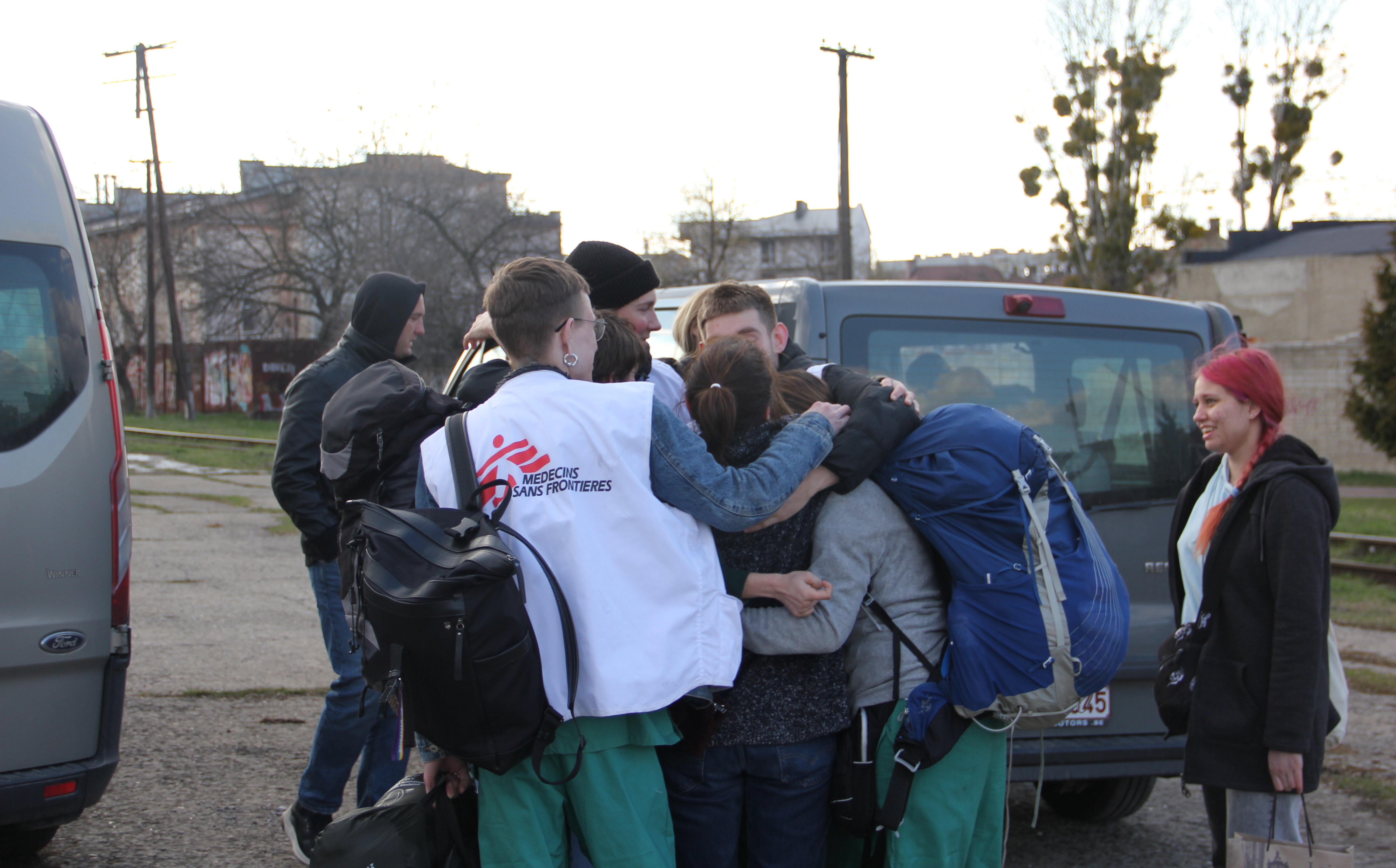 Ett team från Läkare Utan Gränser kramar om varandra på en gata i Lviv, Ukraina.