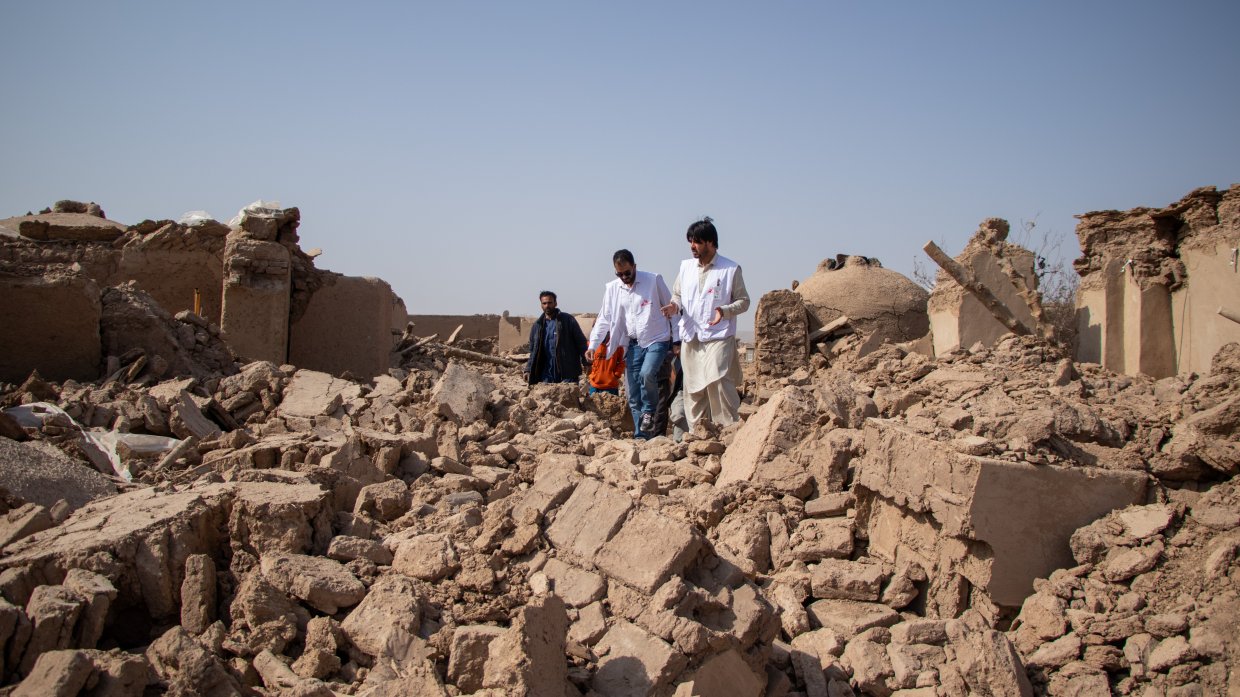 Tre medarbetare från Läkare Utan Gränser går över stora rasmassor efter jordbävningen i Afghanistan