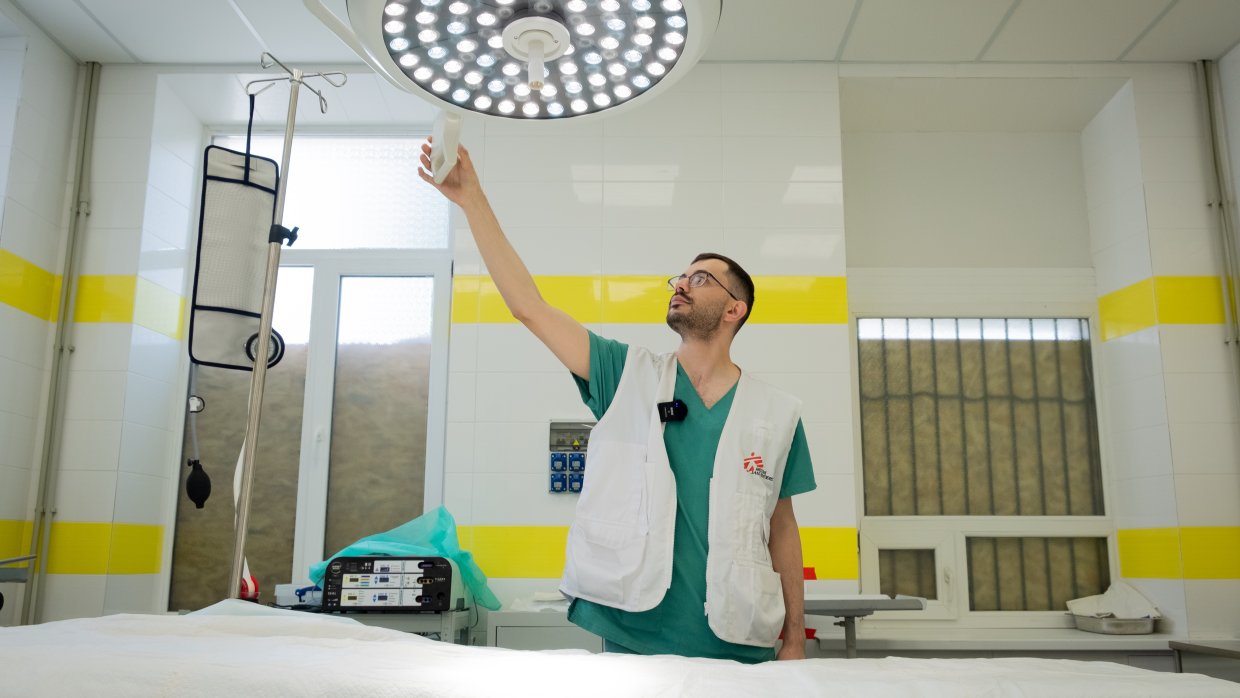 Läkare justerar ljuset över en sjukhussäng.