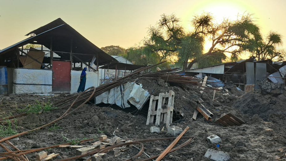 En skadad byggnad med högar med bråte utanför.