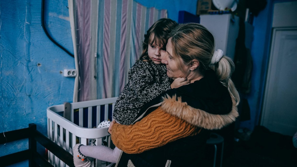 En kvinna med ett barn i famnen.