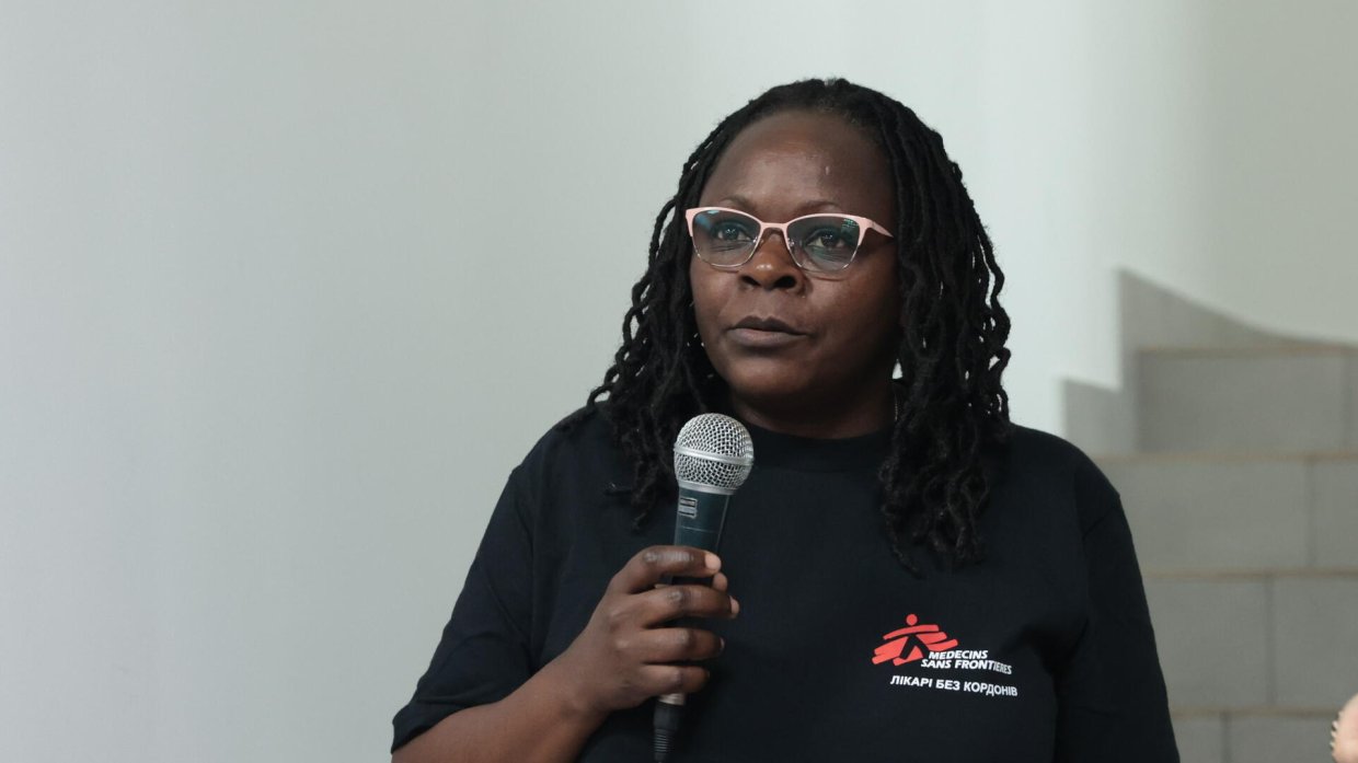 En kvinna med Läkare Utan Gränser-tshirt som håller i en mikrofon.