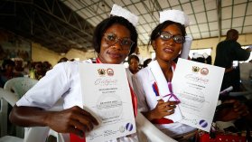 Två barnmorskor visar upp sina examensbevis.