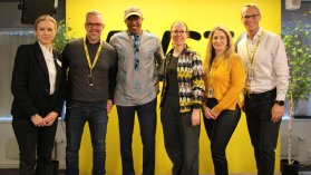 Sex personer från Rusta och Läkare Utan Gränser tittar in i kameran och ler framför Rustas logotyp.