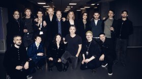 Gruppbild på flertalet svenska artister uppställda mot en svart bakgrund