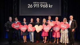 Gruppbild på donationsmottagare på en scen