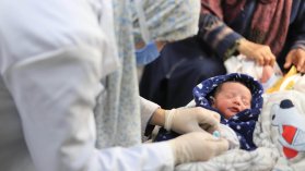 Vårdpersonal undersöker ett nyförlöst barn