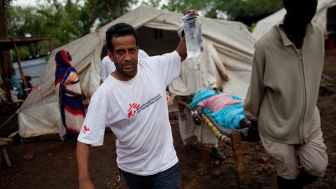 En sjuksköterska tar en patient till en väntande ambulans i flyktinglägret Batil, Sydsudan.