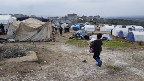 En pojke framför tält