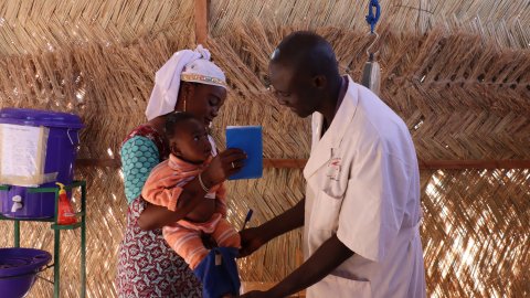 En läkare med en mamma och hennes barn