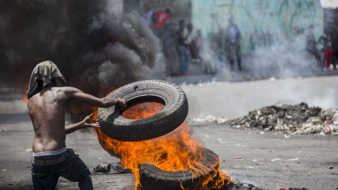 En demonstrant bränner däck i Port-au-Prince