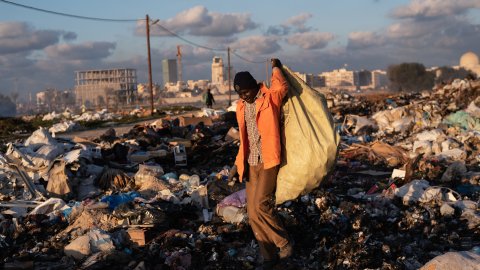 En man samlar skrot på en sopptipp i Libyen.
