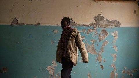 En man tar på sig en kavaj.