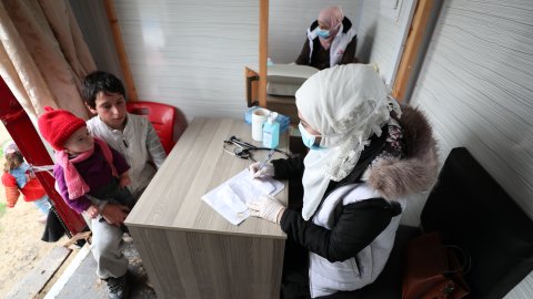 En sjuksköterska konsulterar med en ung pojke i nordvästra Syrien