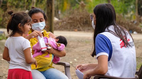 En anställd från Läkare Utan Gränser samtalar med en kvinna och hennes två barn i Choloma, Honduras.