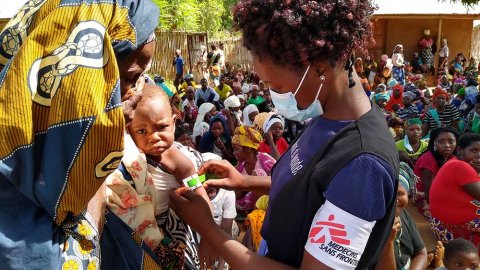 En kvinna från Läkare Utan Gränser mäter överarmen på ett litet barn med måttbandet MUAC i Meluco , provinsen Cabo Delgado i Moçambique.