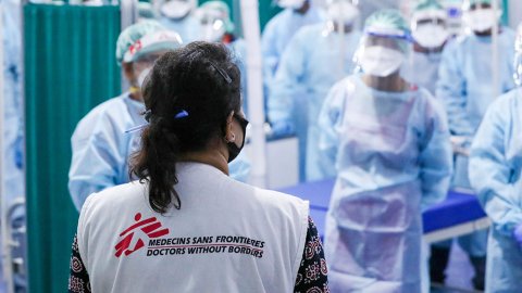 Läkaren Nisha Mohan står med ryggen mot kameran och pratar med personal på vårt  temporärt sjukhus i Patna, Indien.