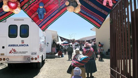 Två kvinnor och ett barn går förbi en ambulans från Läkare Utan Gränser i staden El Alto, granne med huvudstaden La Paz
