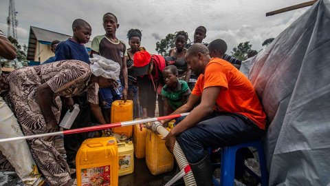 Människor fyller på sina dunkar med rent dricksvatten vid en av våra distributionsplatser i Sake, Kongo-Kinshasa.