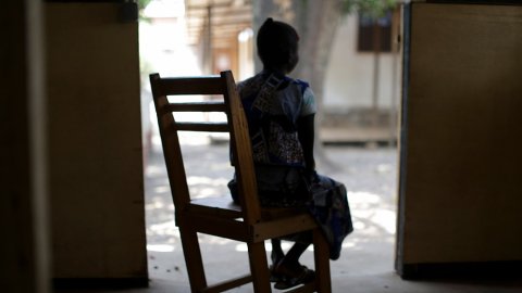 En kvinna i Centralafrikanska republiken sitter i en gungstol med ryggen mot kameran.