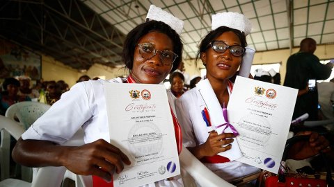 Två barnmorskor visar upp sina examensbevis.
