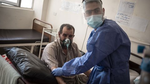 En sjukvårdsanställd tittar till en patient som får syrgas på sjukhuset i Raqqa i nordösta Syrien. 