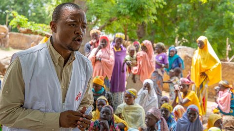 Sjuksköterskan Malik förklarar för invånarna i en by i Niger vad det innebär att vara hälsorådgivare.