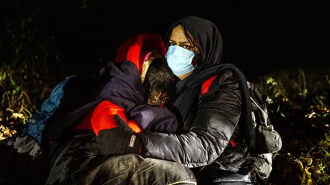 En mamma från Irak kramar sina döttrar, någonstans vid gränsen mellan Polen och Belarus