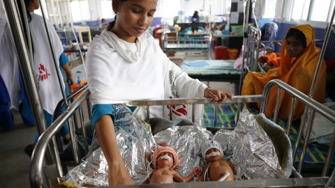 Läkare Utan Gränsers sjuksköterska med ett för tidigt fött tvillingpar som återhämtat sig efter att ha vårdats på avdelningen för nyfödda på sjukhuset i flyktinglägret Cox’s Bazar, Bangladesh