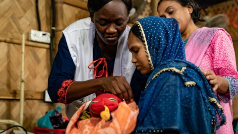 En barnmorska ser till en nyfödd bebis i flyktinglägret Cox's Bazaar i Bangladesh.