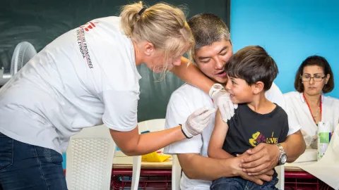 En pojke från Afghanistan får vaccin mot mässling i ett flyktingläger i Grekland