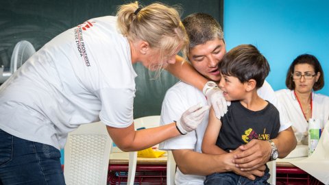En pojke från Afghanistan får vaccin mot mässling i ett flyktingläger i Grekland