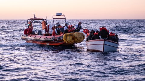 En gummibåt från Läkare Utan Gränsers sök- och räddningsfartyg Geo Barents undsätter en grupp människor från en träbåt på centrala Medelhavet.