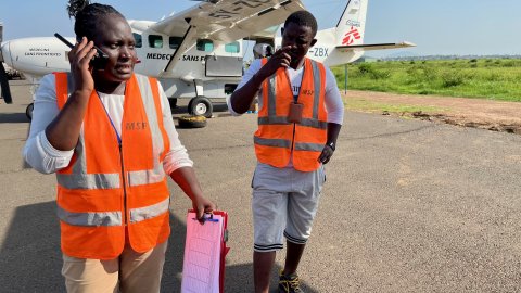 Stella pratar i radion med ett flygplan i bakgrunden