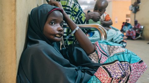 En flicka sitter ner på huk.