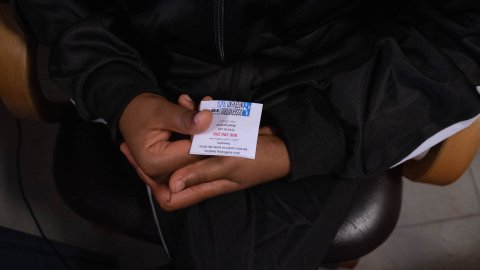 Ett par händer håller i en papperslapp