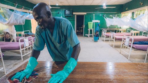 En man som överlevt noma rengör ett bord.