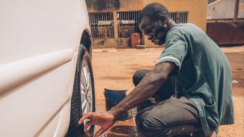 En man tvättar ett bildäck
