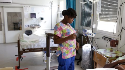 Sjuksköterskan Gessica i Haiti talar med en patient som ligger i en sjukhussäng
