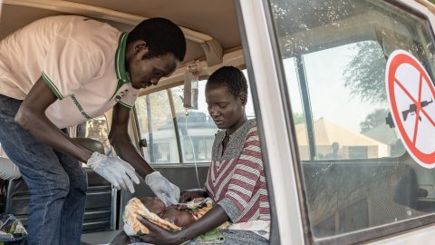 en kvinna med sin sjuka bebis i en ambulans 