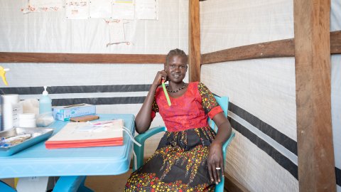 hälsoarbetaren Margaret Abuk sitter vid ett bord på en hälsomottagning i flyktinglägret Majar Aher i Sydsudan