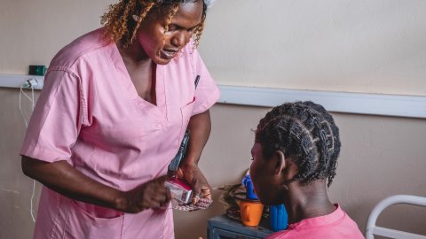 Barnmorska ger medicin till patient.