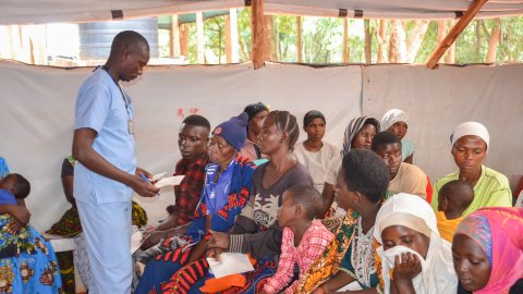 Manlig sjuksköterska tar hand om patienter. 