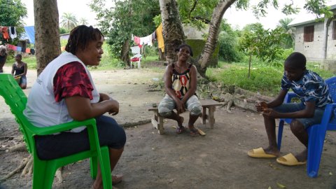 Kvinnlig personal pratar med två patienter.