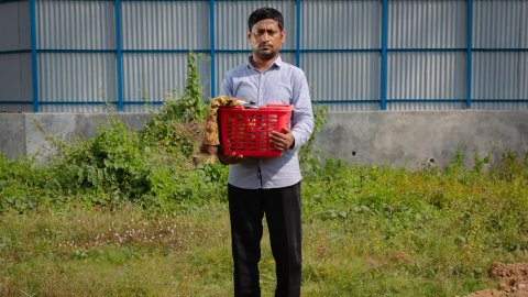 Man står med liten korg i famnen.