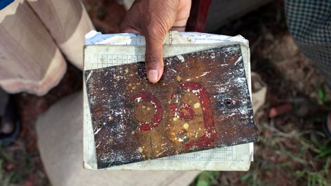 Hand visar upp rostig skylt med nummer på.