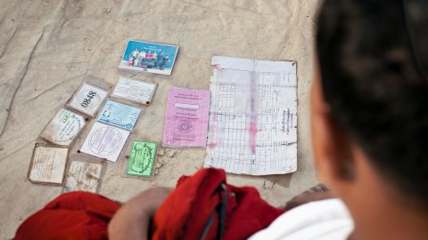 Ryggen av en man som tittar på dokument liggande framför sig.