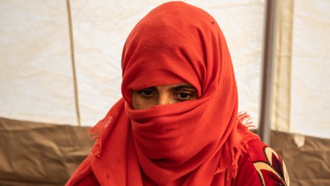 Närbild när en kvinna med röd hijab som tittar neråt.