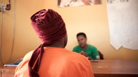 bild tagen bakifrån på en kvinna som sitter framför ett skrivbord